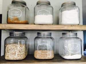 Glass jars lined up in a pantry.