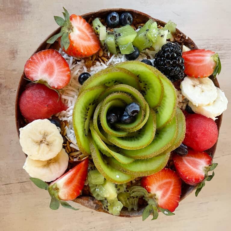 Smoothie bowl topped with kiwi, strawberry, banana, blueberries.