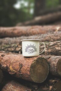 Camping coffee mug on a log.