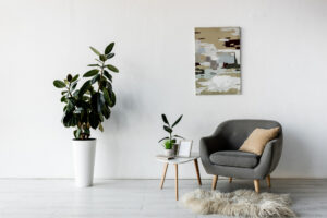 Minimalist living room with couch, table, plant, and wall art.