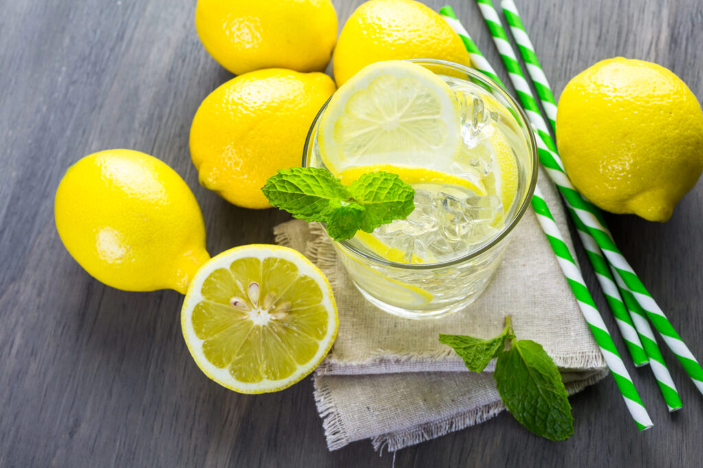 lemons around a glass of water, garnished with mint.