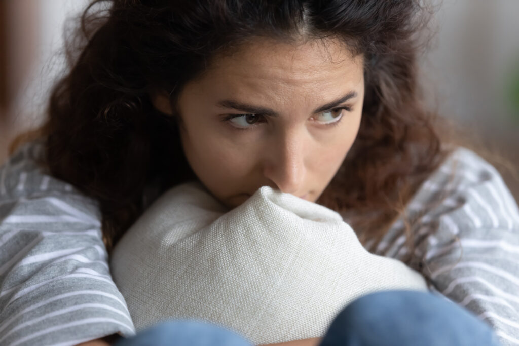Woman hugging a pillow looking sad and depressed.