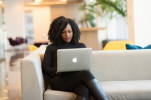 Woman typing on her laptop on a couch.