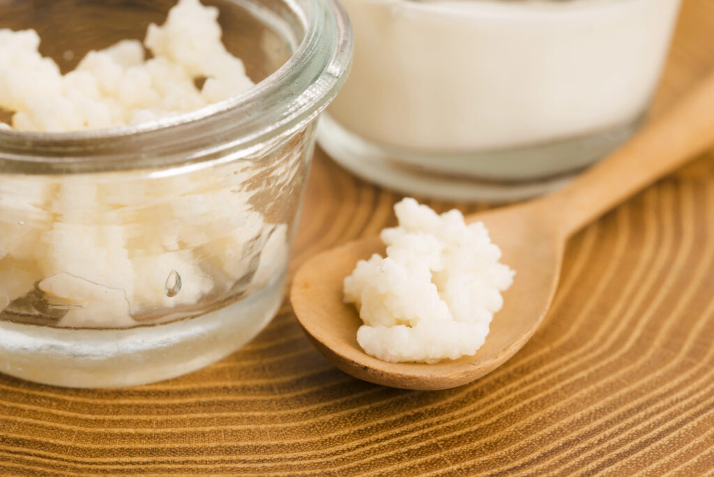 Homemade sugar scrub in a small glass jar with a scoop.