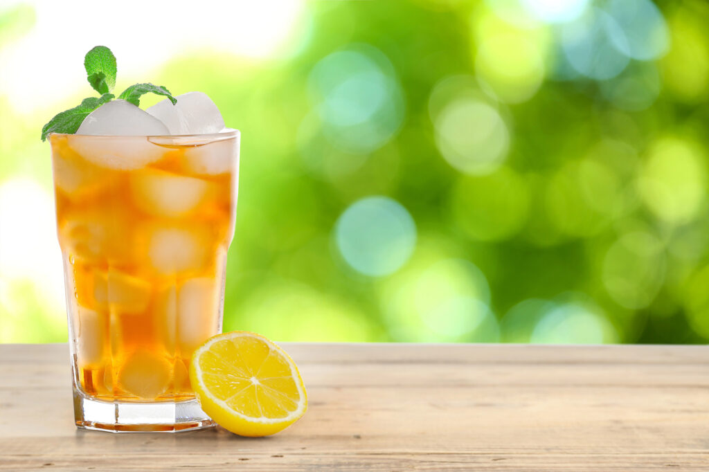 Glass of tea on a picnic table.
