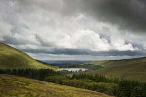 Cloudy view of mountains by a lake,