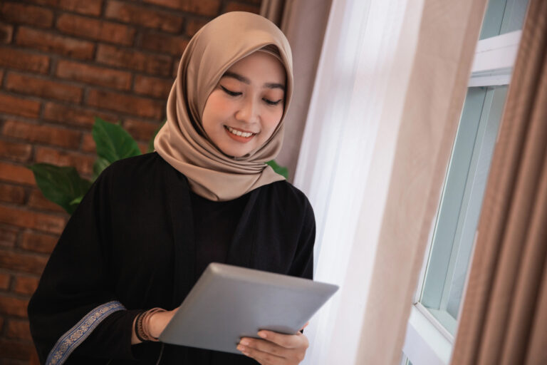 Woman wearing a scarf looking at her ipad.