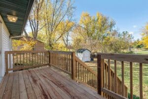 View of a backyard and white shed from a deck.
