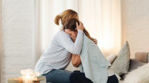 Mom hugging her daughter.
